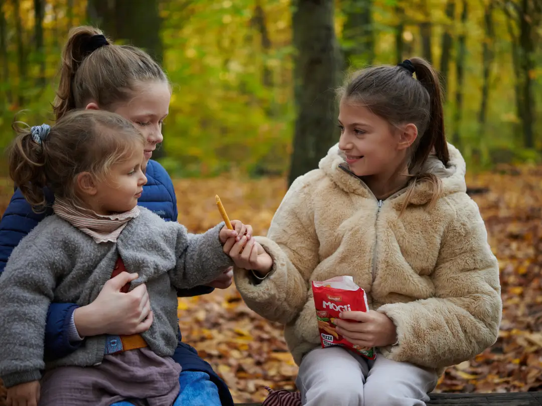 Kinder teilen sich Pizza Stangen im Wald